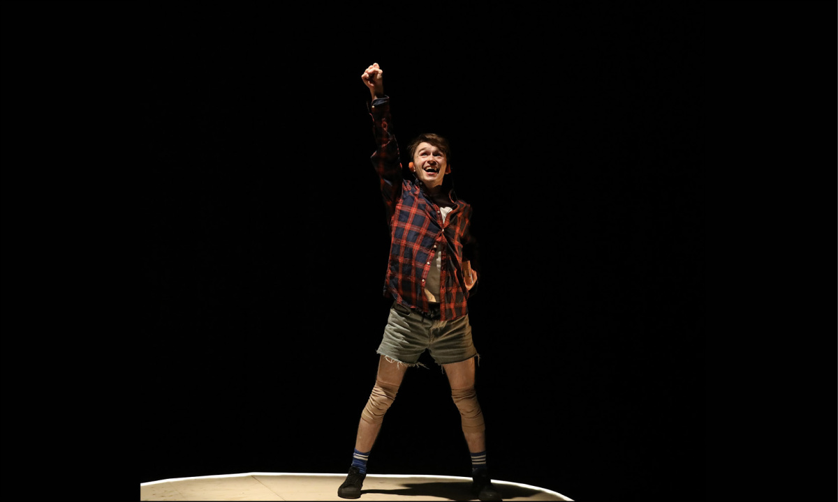 En pojke sträcker upp en hand i luften