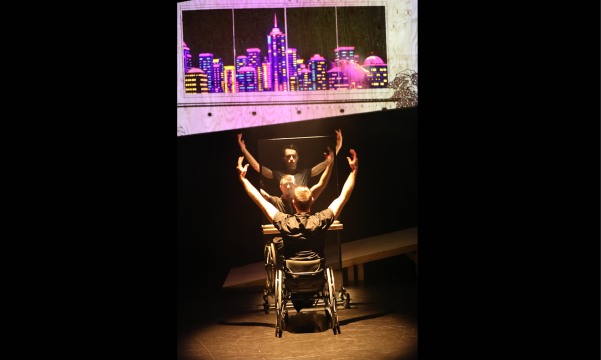 Två dansare syns i en spegelreflektion med en bild av en skyline bakom